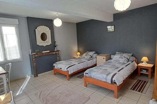 une chambre avec deux lits dans une pièce dans l'établissement Maison avec cour fermée, à Gratibus