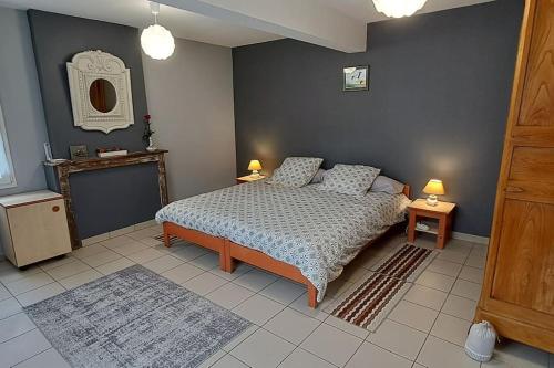 - une chambre avec un lit, deux tables et une cheminée dans l'établissement Maison avec cour fermée, à Gratibus