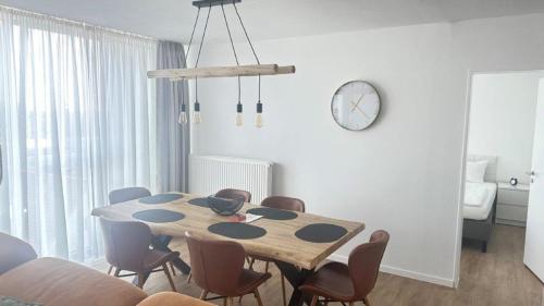 a dining room table with chairs and a clock on the wall at PANORAMA HOTEL in Neustadt an der Weinstraße in Neustadt an der Weinstraße