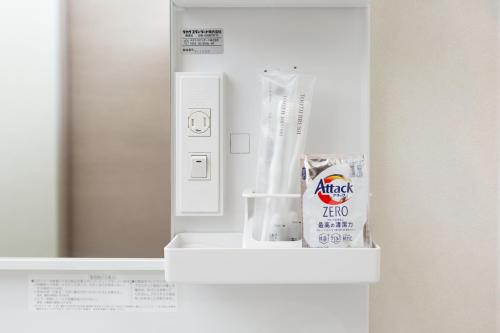 a small white refrigerator with a tube of toothpaste at Residence Hotel Hakata Minoshima in Fukuoka