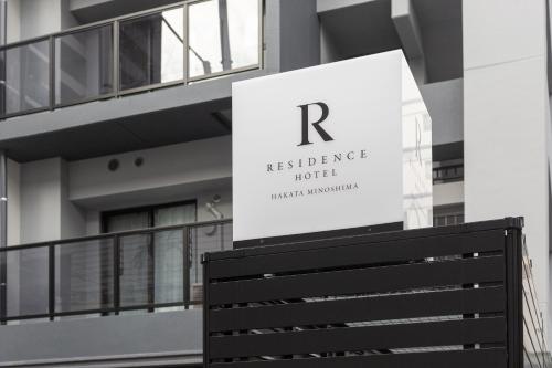 a sign for the reclusive hotel in front of a building at Residence Hotel Hakata Minoshima in Fukuoka