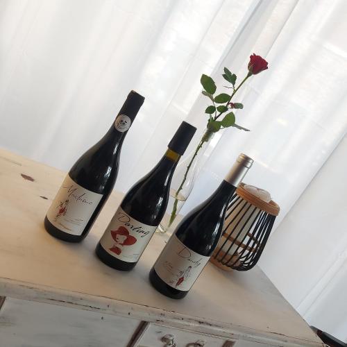 three bottles of wine on a table with a flower at Escale au Salagou in Le Bosc