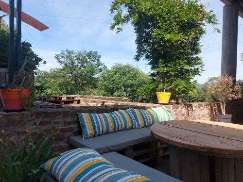 a patio with a bench and a wooden table at Escale au Salagou in Le Bosc