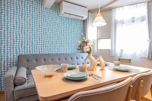a dining room with a table and a couch at Asakusa and Ueno Area, 2 Minutes to Iriya Station, Very Convenient in Tokyo
