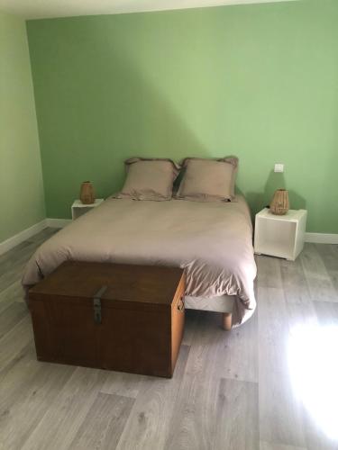 une chambre avec un grand lit avec un plancher en bois dans l'établissement T2 avec terrasse calme et ensoleillée, à Saint-Claude