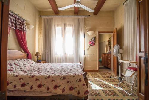 a bedroom with a large bed and a window at 4 Bedroom Farmhouse with Private Pool in Island of Gozo in Żebbuġ