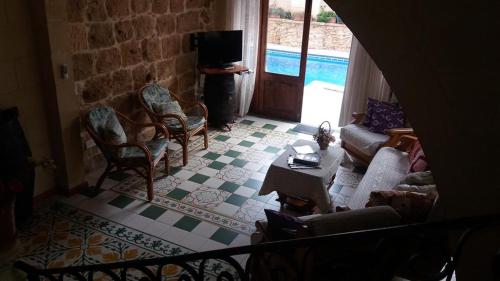 a living room with a couch and chairs and a tv at 4 Bedroom Farmhouse with Private Pool in Island of Gozo in Żebbuġ