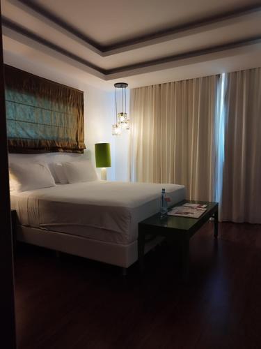 a bedroom with a large bed and a table at Salvator Villas & Spa Hotel in Parga