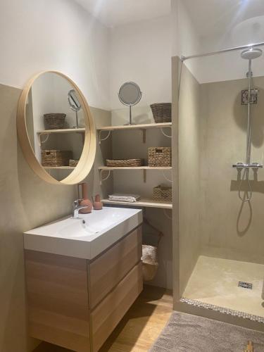 une salle de bain avec un lavabo et un miroir dans l'établissement La Magnanerie d aubais, à Aubais