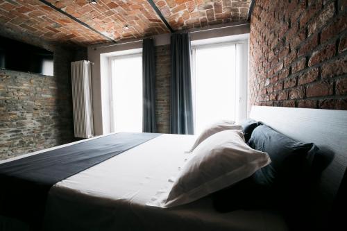 a bed in a room with a brick wall at Country House Villa Barbero - Entire House in Mango