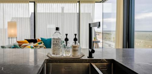 two bottles of alcohol sitting on top of a kitchen counter at Penthouse La Naturale zeezicht in Zeebrugge
