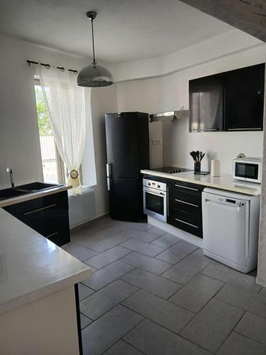 Il comprend une cuisine équipée d'un réfrigérateur noir. dans l'établissement Maison au Choux Loiret, à Les Choux