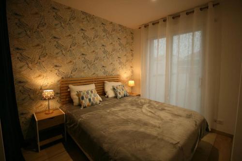 une chambre avec un grand lit et une fenêtre dans l'établissement Villa quelques pas de la plage et des commerces, à La Tranche-sur-Mer