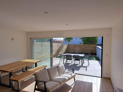 un salon avec un canapé et une table dans l'établissement Villa quelques pas de la plage et des commerces, à La Tranche-sur-Mer