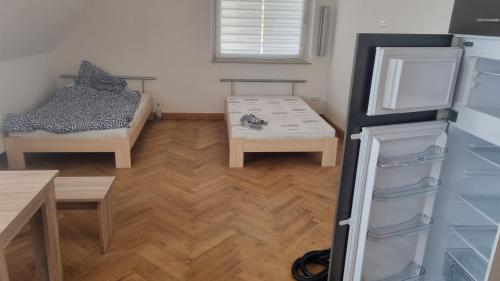 a room with a refrigerator and a table and a bed at Rot Monteurzimmer in Paderborn