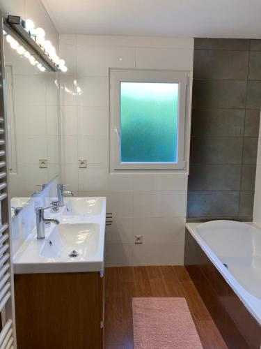 米洛Chambre dans villa cosy avec terrasse的带水槽、浴缸和窗户的浴室