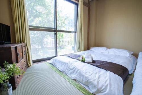 a bedroom with a bed and a large window at Toko inn courtyard in Tokyo