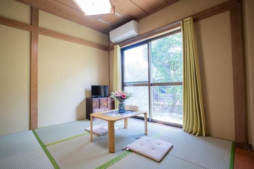 a living room with a table and a window at Toko inn courtyard in Tokyo