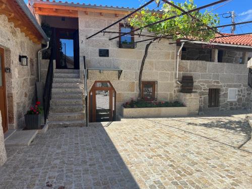 a stone building with a staircase and a door at Eido de Bairros - Casa Vinha da Touça T1 in Soajo