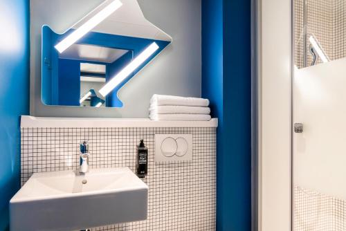 a bathroom with a white sink and a mirror at ibis Budget La Rochelle Centre gare in La Rochelle