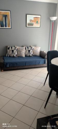 a living room with a blue couch and a table at Andriannas apartment-parking lot included in Patra