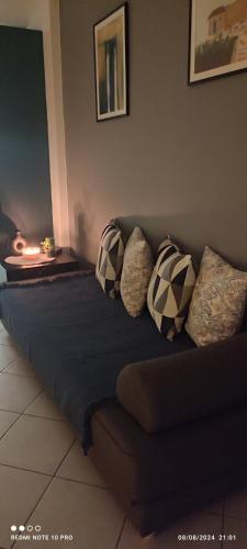 a couch in a living room with pillows on it at Andriannas apartment-parking lot included in Patra
