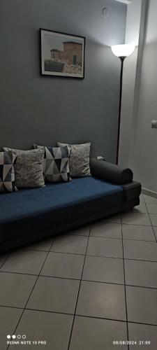 a couch sitting on a tiled floor in a room at Andriannas apartment-parking lot included in Patra