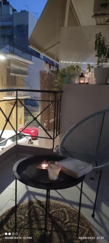 a table on a balcony with an umbrella at Andriannas apartment-parking lot included in Patra