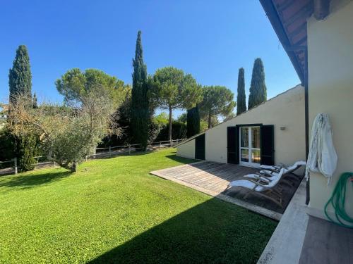 a house with a yard with chairs and trees at Villaimmersanellecollinetoscane in Pescia Romana