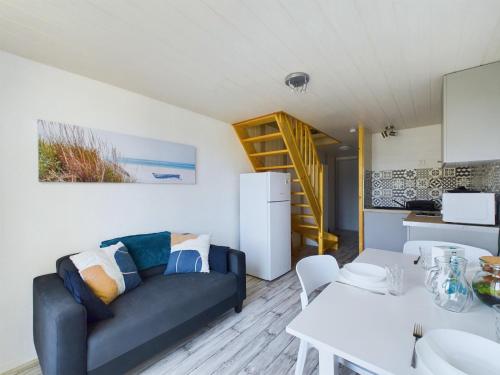 un salon avec un canapé et une table dans l'établissement À 150m de la plage, appartement mezzanine pour 4, à Les Bussolleries