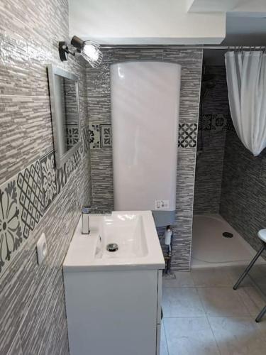 une salle de bain avec un lavabo blanc et une douche dans l'établissement Maison 47m2 à 800 m de la plage, à Saint-Raphaël