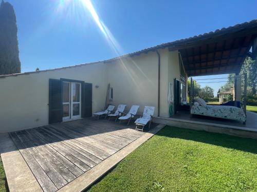 a deck with chairs and a couch on a house at Villaimmersanellecollinetoscane in Pescia Romana