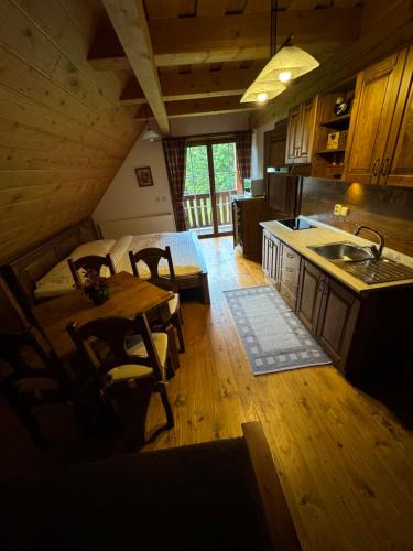 a kitchen and dining room with a table and a sink at Horská Chata Raj in Liptovský Ján