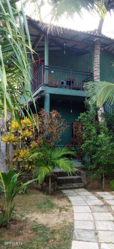 a house with a balcony with a table and chairs at Green House Yala in Kirinda