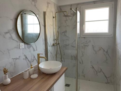 une salle de bain avec un lavabo et une douche avec un miroir dans l'établissement Magnifique appartement 2p à Cannes avec vue mer, à Cannes