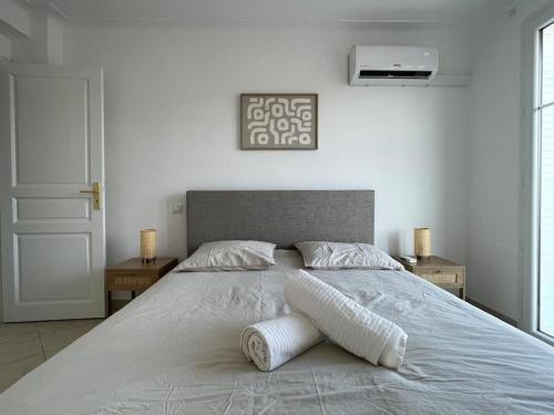 une chambre avec un grand lit blanc avec deux tables dans l'établissement Magnifique appartement 2p à Cannes avec vue mer, à Cannes