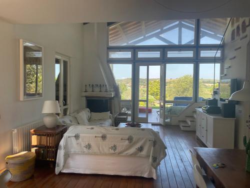 a bedroom with a large bed and a large window at Villaimmersanellecollinetoscane in Pescia Romana