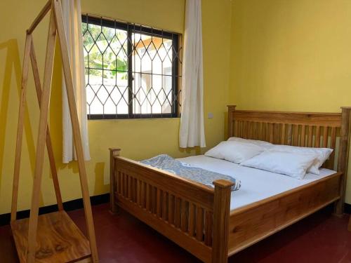 モシにあるChic Kilimanjaro Getaway Spotの窓付きの部屋の木製ベッド1台