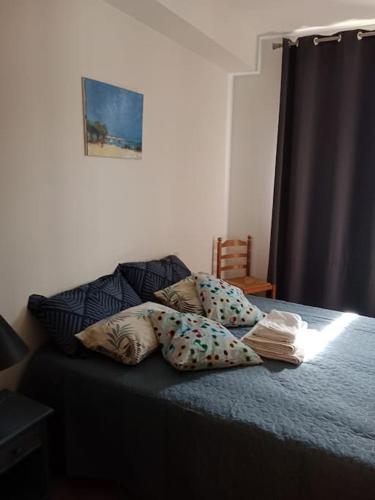 une chambre avec un lit avec des oreillers dessus dans l'établissement T2 climatisé avec jardin privatif et stationnement, à Perpignan