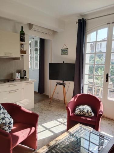 un salon avec deux chaises et une table dans l'établissement T2 climatisé avec jardin privatif et stationnement, à Perpignan