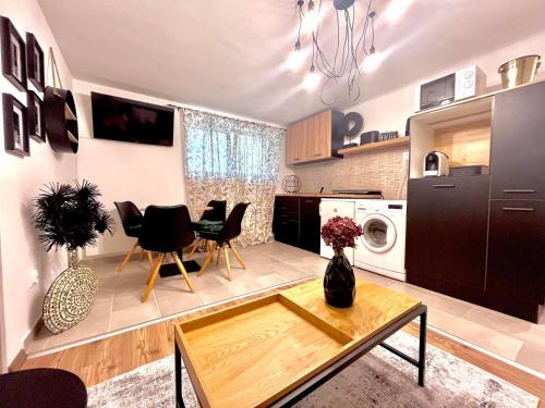 a kitchen and living room with a table and chairs at Middle of the city apartmann in Pécs