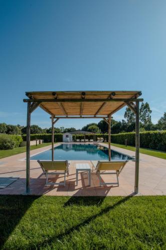 a gazebo with benches and a swimming pool at Agriturismo Canova - Private Villas in Marina di Grosseto