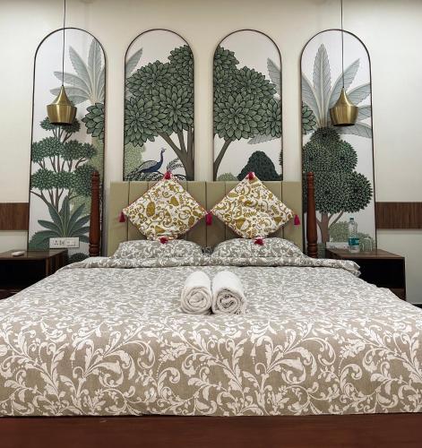 a bedroom with a large bed with two towels on it at Mayilveedu Guest House in Tuticorin