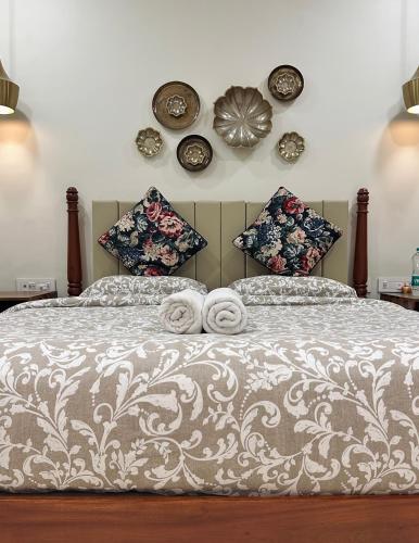 a bedroom with a bed with pillows and plates on the wall at Mayilveedu Guest House in Tuticorin
