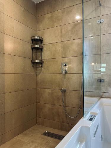 a bathroom with a shower with a tub and a sink at Mayilveedu Guest House in Tuticorin