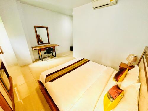 a bedroom with a bed and a desk with a mirror at patong v hotel in Patong Beach