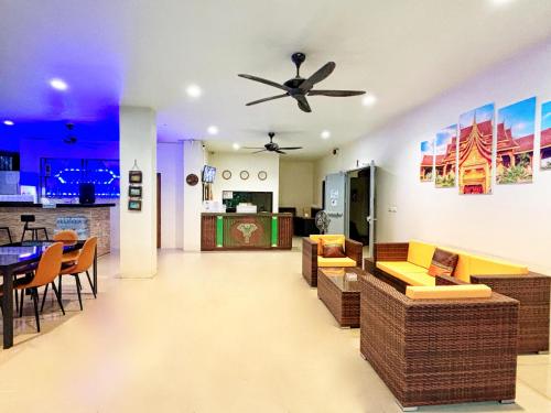 a living room with a ceiling fan and a dining room at patong v hotel in Patong Beach