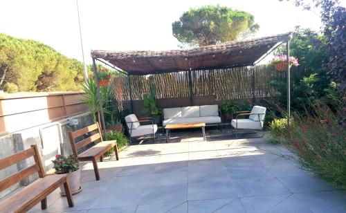 a patio with a bench and a table and chairs at Casa Atenea in Caldes de Malavella
