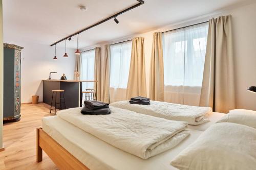 two beds in a room with windows and a desk at Alte Seifensiederei - Rainer Maria in Bad Tölz