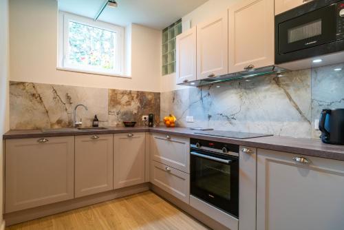 une cuisine avec des armoires blanches et une fenêtre dans l'établissement Studio Marin - Studio vue mer, à Erquy